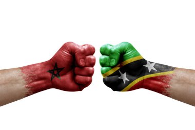 Two hands punch to each others on white background. Country flags painted fists, conflict crisis concept between morocco and saint kitts and nevis