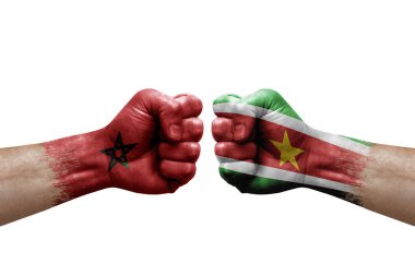 Two hands punch to each others on white background. Country flags painted fists, conflict crisis concept between morocco and suriname