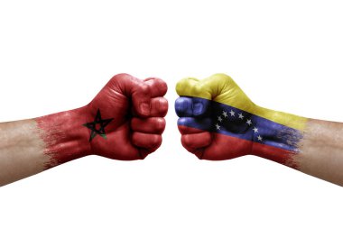 Two hands punch to each others on white background. Country flags painted fists, conflict crisis concept between morocco and venezuela