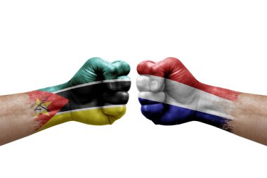Two hands punch to each others on white background. Country flags painted fists, conflict crisis concept between mozambique and netherlands