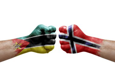 Two hands punch to each others on white background. Country flags painted fists, conflict crisis concept between mozambique and norway