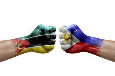 Two hands punch to each others on white background. Country flags painted fists, conflict crisis concept between mozambique and philippines