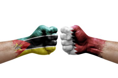 Two hands punch to each others on white background. Country flags painted fists, conflict crisis concept between mozambique and qatar
