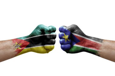 Two hands punch to each others on white background. Country flags painted fists, conflict crisis concept between mozambique and south sudan