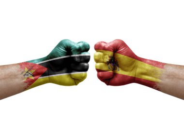 Two hands punch to each others on white background. Country flags painted fists, conflict crisis concept between mozambique and spain