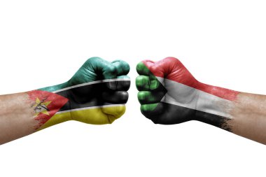 Two hands punch to each others on white background. Country flags painted fists, conflict crisis concept between mozambique and sudan