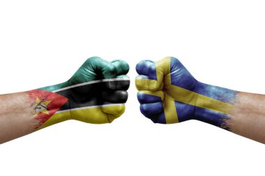 Two hands punch to each others on white background. Country flags painted fists, conflict crisis concept between mozambique and sweden