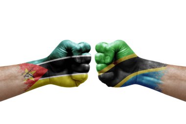 Two hands punch to each others on white background. Country flags painted fists, conflict crisis concept between mozambique and tanzania