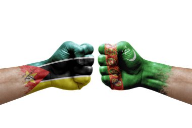 Two hands punch to each others on white background. Country flags painted fists, conflict crisis concept between mozambique and turkmenistan