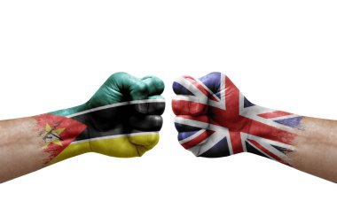 Two hands punch to each others on white background. Country flags painted fists, conflict crisis concept between mozambique and united kingdom