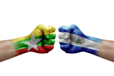 Two hands punch to each others on white background. Country flags painted fists, conflict crisis concept between myanmar and nicaragua