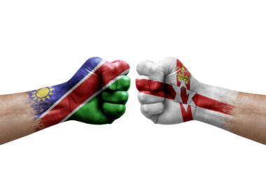 Two hands punch to each others on white background. Country flags painted fists, conflict crisis concept between namibia and ireland