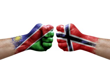 Two hands punch to each others on white background. Country flags painted fists, conflict crisis concept between namibia and norway