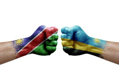 Two hands punch to each others on white background. Country flags painted fists, conflict crisis concept between namibia and rwanda