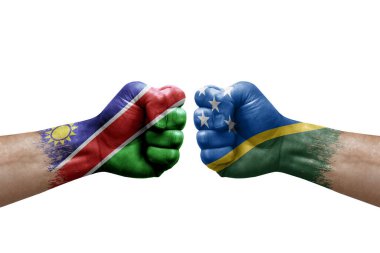 Two hands punch to each others on white background. Country flags painted fists, conflict crisis concept between namibia and solomon islands