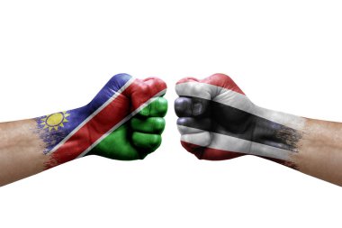 Two hands punch to each others on white background. Country flags painted fists, conflict crisis concept between namibia and thailand