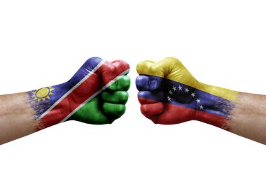 Two hands punch to each others on white background. Country flags painted fists, conflict crisis concept between namibia and venezuela