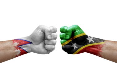 Two hands punch to each others on white background. Country flags painted fists, conflict crisis concept between nepal and saint kitts and nevis