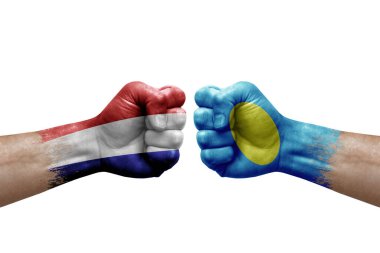 Two hands punch to each others on white background. Country flags painted fists, conflict crisis concept between netherlands and palau