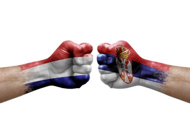 Two hands punch to each others on white background. Country flags painted fists, conflict crisis concept between netherlands and serbia