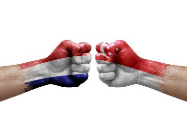 Two hands punch to each others on white background. Country flags painted fists, conflict crisis concept between netherlands and singapore
