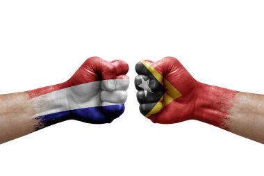 Two hands punch to each others on white background. Country flags painted fists, conflict crisis concept between netherlands and timor leste