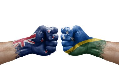 Two hands punch to each others on white background. Country flags painted fists, conflict crisis concept between new zealand and solomon islands
