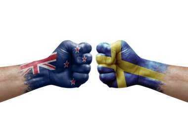 Two hands punch to each others on white background. Country flags painted fists, conflict crisis concept between new zealand and sweden