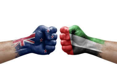 Two hands punch to each others on white background. Country flags painted fists, conflict crisis concept between new zealand and united arab emirates