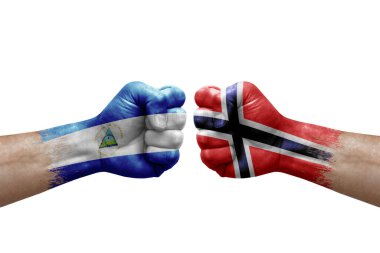 Two hands punch to each others on white background. Country flags painted fists, conflict crisis concept between nicaragua and norway