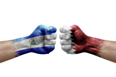 Two hands punch to each others on white background. Country flags painted fists, conflict crisis concept between nicaragua and qatar