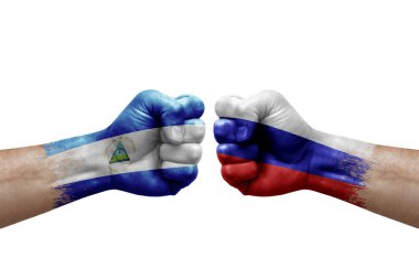Two hands punch to each others on white background. Country flags painted fists, conflict crisis concept between nicaragua and russia