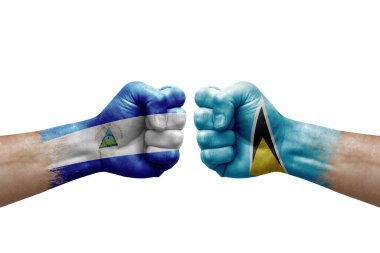 Two hands punch to each others on white background. Country flags painted fists, conflict crisis concept between nicaragua and saint lucia