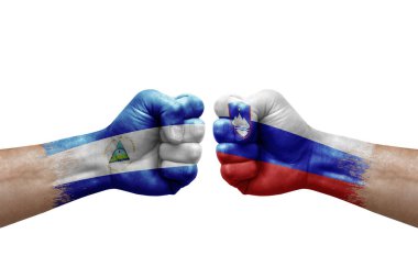 Two hands punch to each others on white background. Country flags painted fists, conflict crisis concept between nicaragua and slovenia