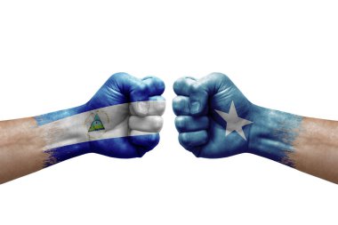 Two hands punch to each others on white background. Country flags painted fists, conflict crisis concept between nicaragua and somalia