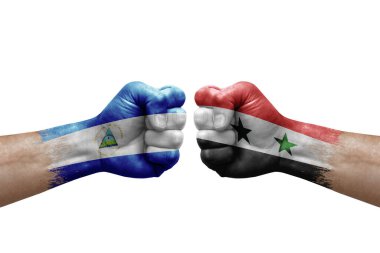 Two hands punch to each others on white background. Country flags painted fists, conflict crisis concept between nicaragua and syria