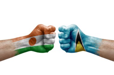 Two hands punch to each others on white background. Country flags painted fists, conflict crisis concept between niger and saint lucia