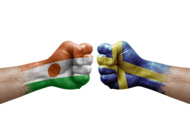 Two hands punch to each others on white background. Country flags painted fists, conflict crisis concept between niger and sweden
