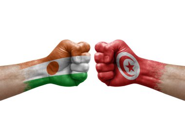 Two hands punch to each others on white background. Country flags painted fists, conflict crisis concept between niger and tunisia