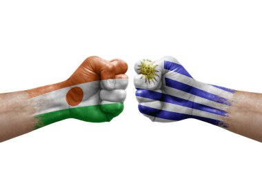 Two hands punch to each others on white background. Country flags painted fists, conflict crisis concept between niger and uruguay