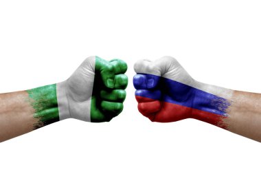 Two hands punch to each others on white background. Country flags painted fists, conflict crisis concept between nigeria and russia