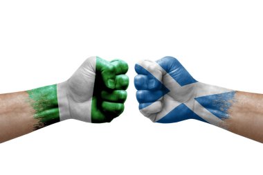 Two hands punch to each others on white background. Country flags painted fists, conflict crisis concept between nigeria and scotland
