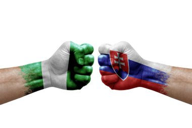 Two hands punch to each others on white background. Country flags painted fists, conflict crisis concept between nigeria and slovakia
