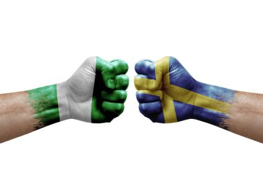 Two hands punch to each others on white background. Country flags painted fists, conflict crisis concept between nigeria and sweden