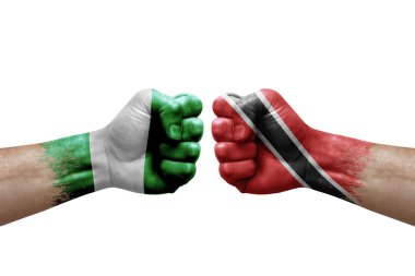 Two hands punch to each others on white background. Country flags painted fists, conflict crisis concept between nigeria and tobago