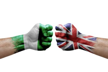 Two hands punch to each others on white background. Country flags painted fists, conflict crisis concept between nigeria and united kingdom