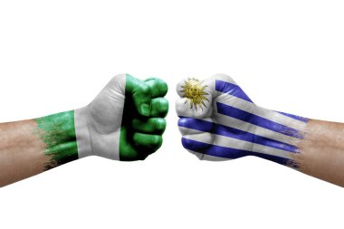 Two hands punch to each others on white background. Country flags painted fists, conflict crisis concept between nigeria and uruguay