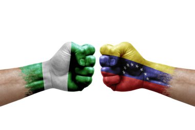 Two hands punch to each others on white background. Country flags painted fists, conflict crisis concept between nigeria and venezuela