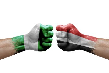 Two hands punch to each others on white background. Country flags painted fists, conflict crisis concept between nigeria and yemen