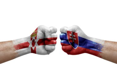 Two hands punch to each others on white background. Country flags painted fists, conflict crisis concept between northern ireland and slovakia